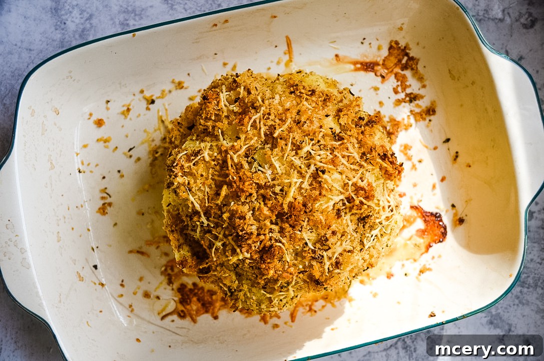 Golden Cheddar Stuffed Cauliflower 5 A side view of the baked cauliflower dish, highlighting the crispy breading and the rich texture, presented in a rustic baking dish.