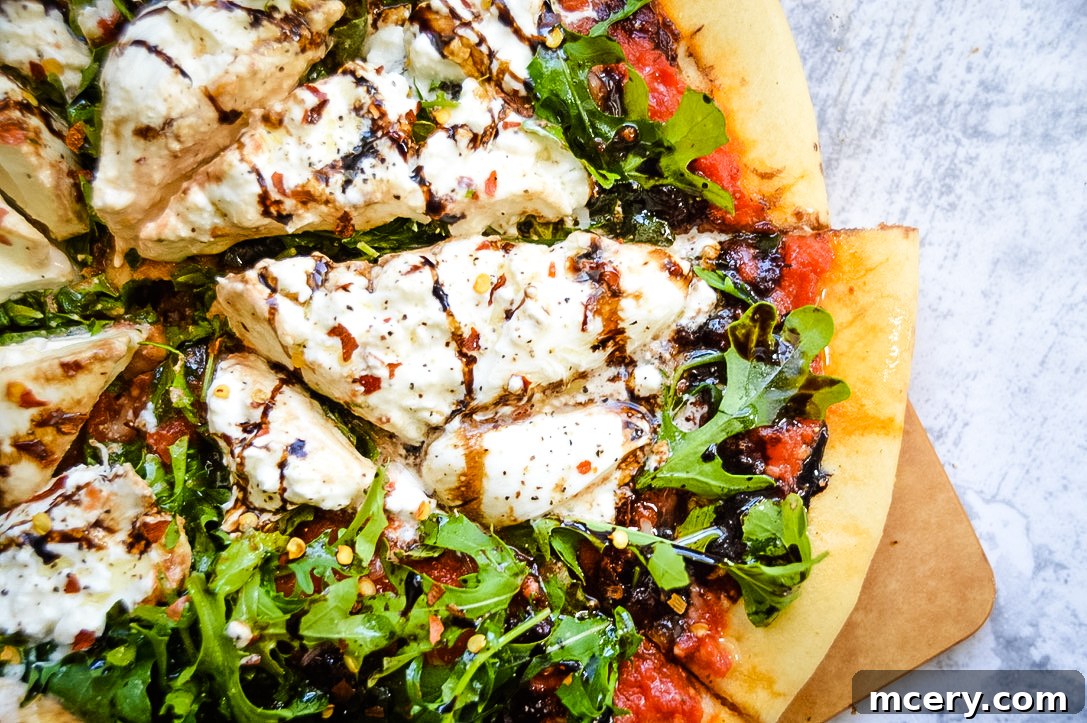 Burrata and Truffle Oil Pizza - A freshly baked pizza with burrata, arugula, and balsamic glaze.
