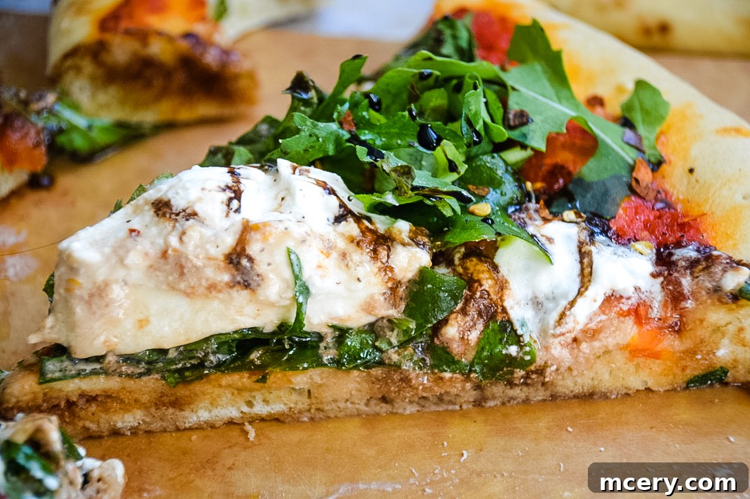 Freshly baked Burrata and Truffle Oil Pizza, garnished with arugula and balsamic glaze.