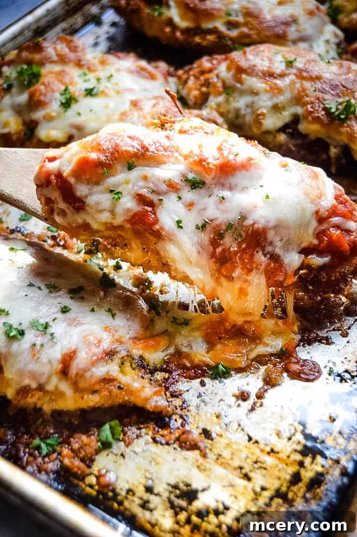 Crispy Chicken Parmesan with melted mozzarella cheese and fresh basil on top, ready to serve.