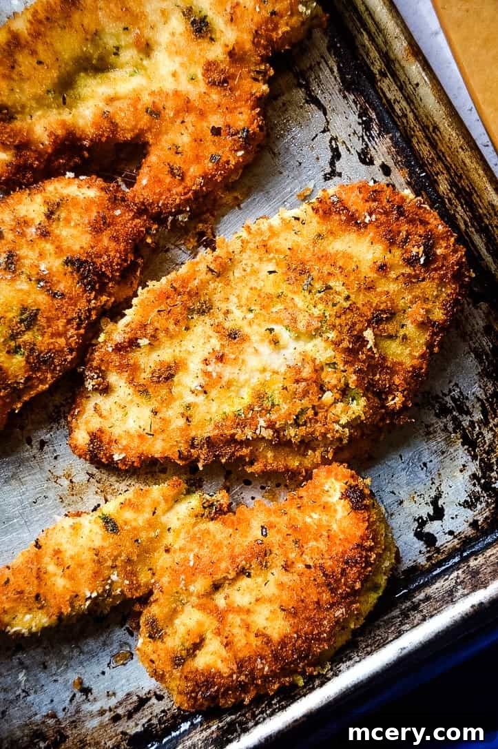 Four crispy chicken parmesan cutlets layered with marinara and melted mozzarella, ready for serving.