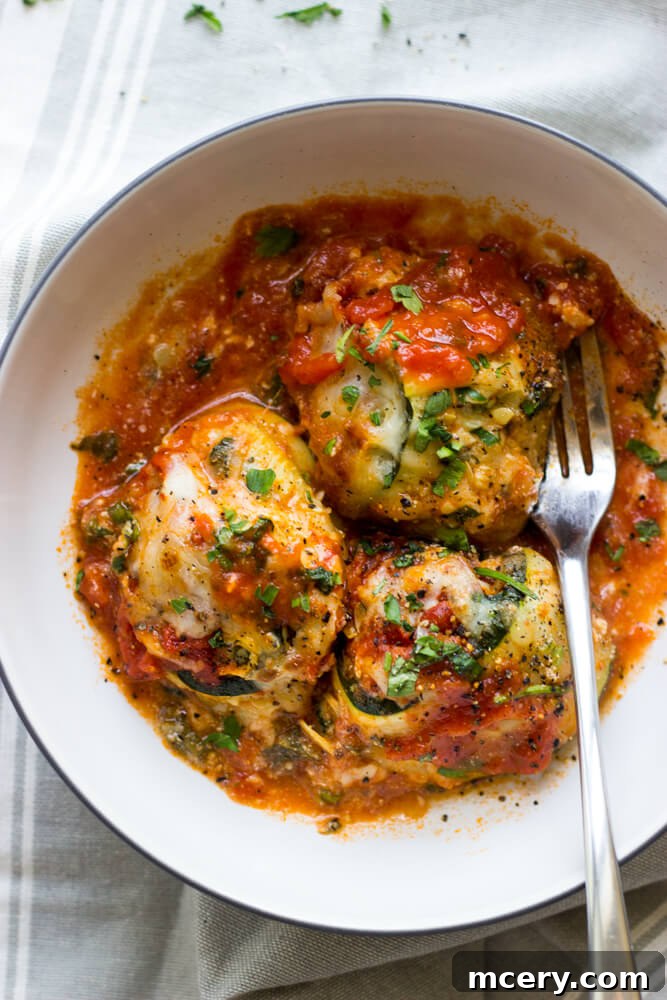 Close-up of baked zucchini lasagna rolls showcasing the creamy filling and golden cheese.