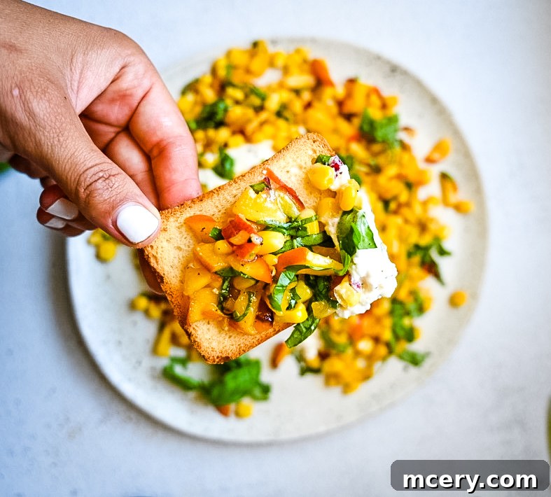 A serving of Peach, Corn & Burrata Salad on a rustic plate, garnished with fresh herbs and ready to eat.