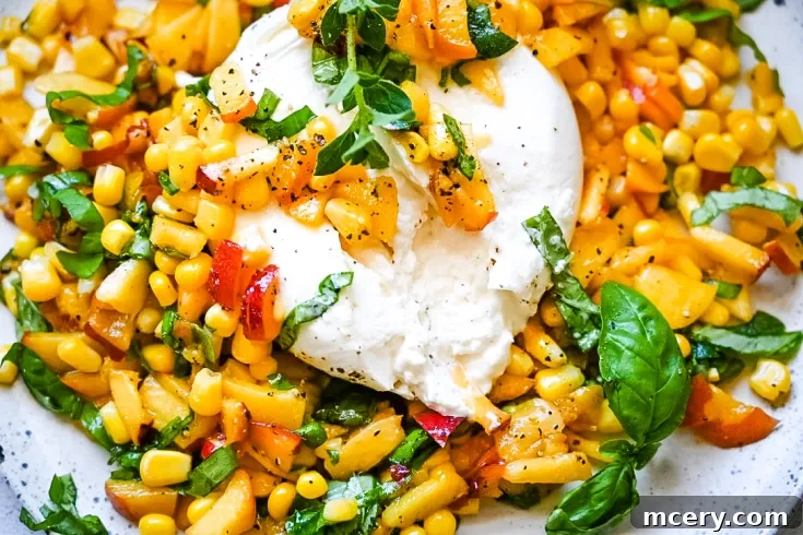 A vibrant and appetizing Peach, Corn & Burrata Salad, garnished with fresh herbs, ready to be served.