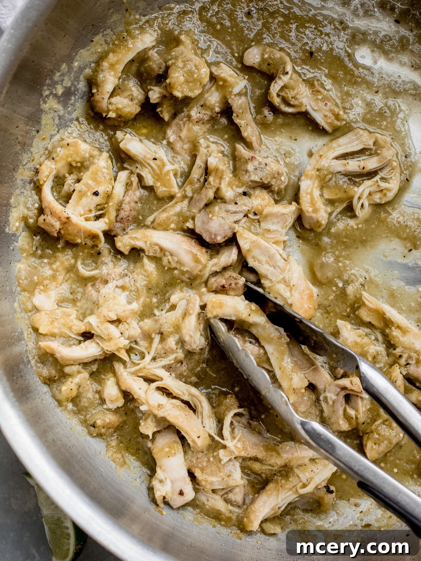 Sizzling Chicken Fajita Bowl 3 Close-up of shredded salsa verde chicken simmering in a large pan, ready for assembly into bowls.