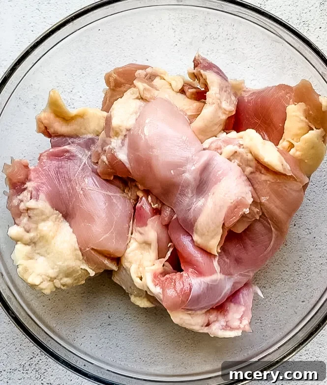 Chicken thighs marinating in a bowl.