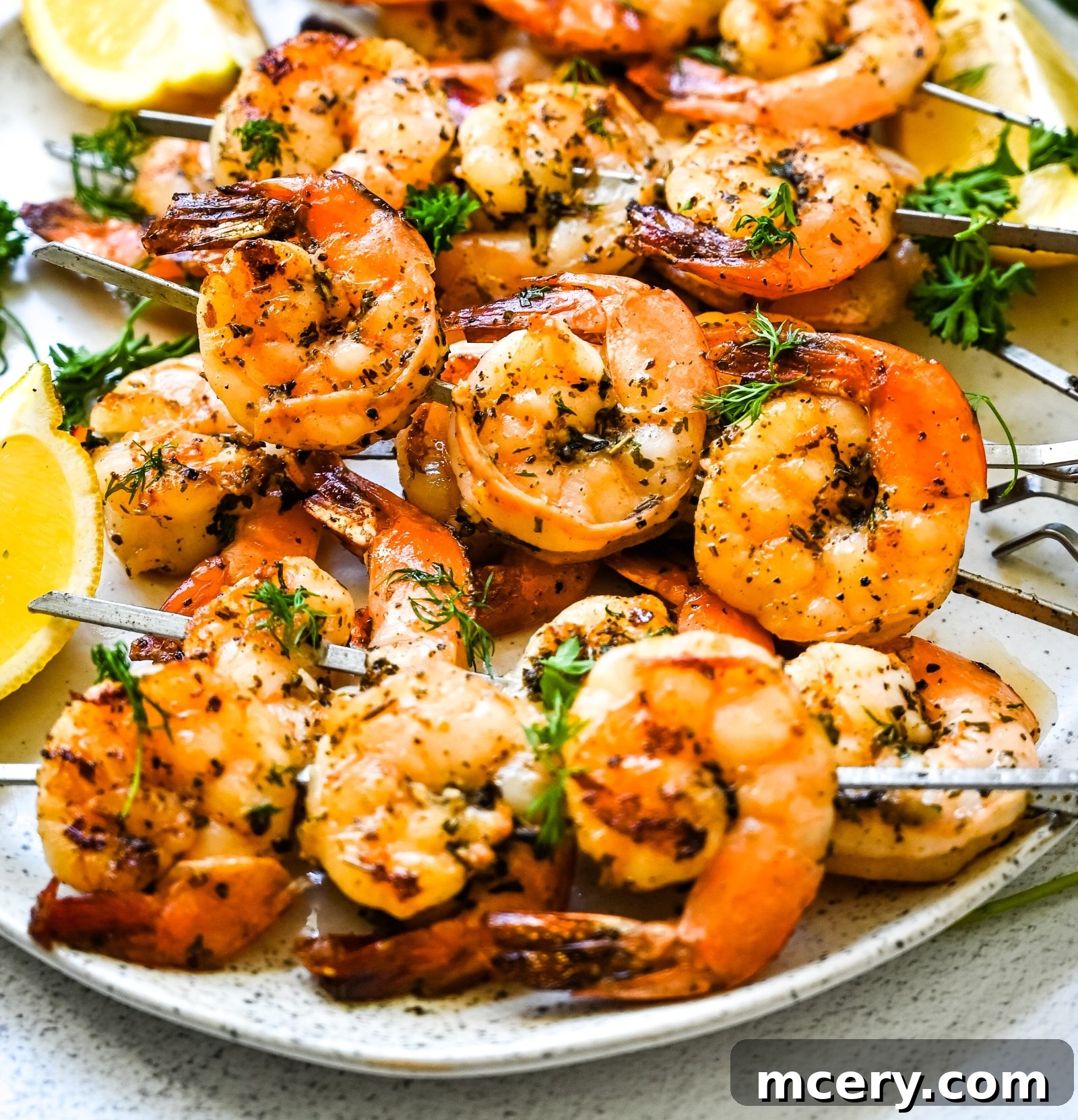 Chargrilled Garlic Herb Shrimp Skewers 2 Garlic Herb Grilled Shrimp Skewers arranged neatly on a platter, garnished with fresh parsley and lemon wedges.