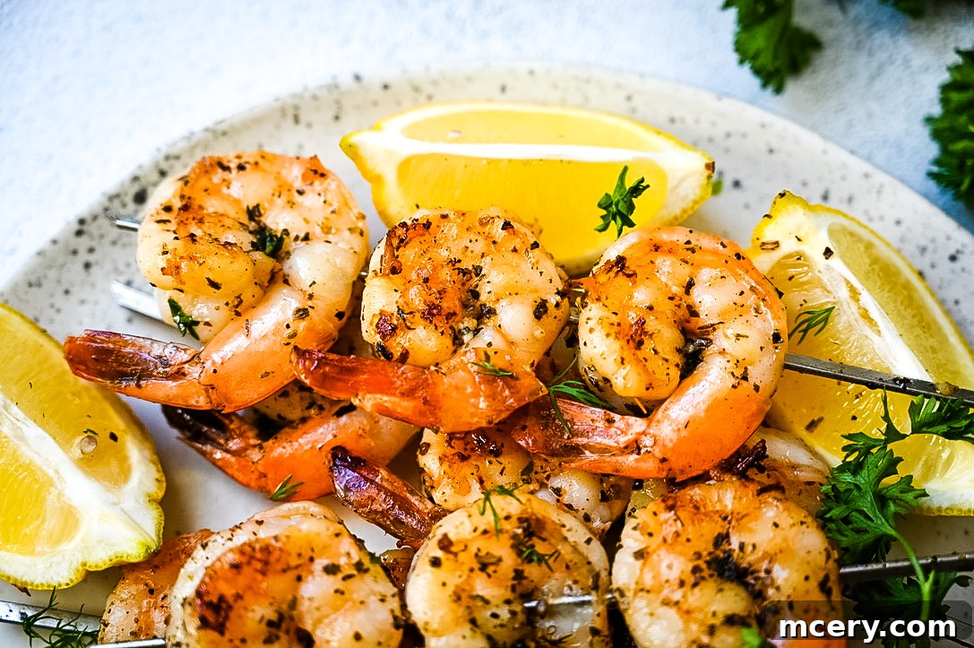 Chargrilled Garlic Herb Shrimp Skewers 5 A serving of Garlic Herb Grilled Shrimp Skewers with fresh lemon wedges and herbs, ready to be enjoyed.