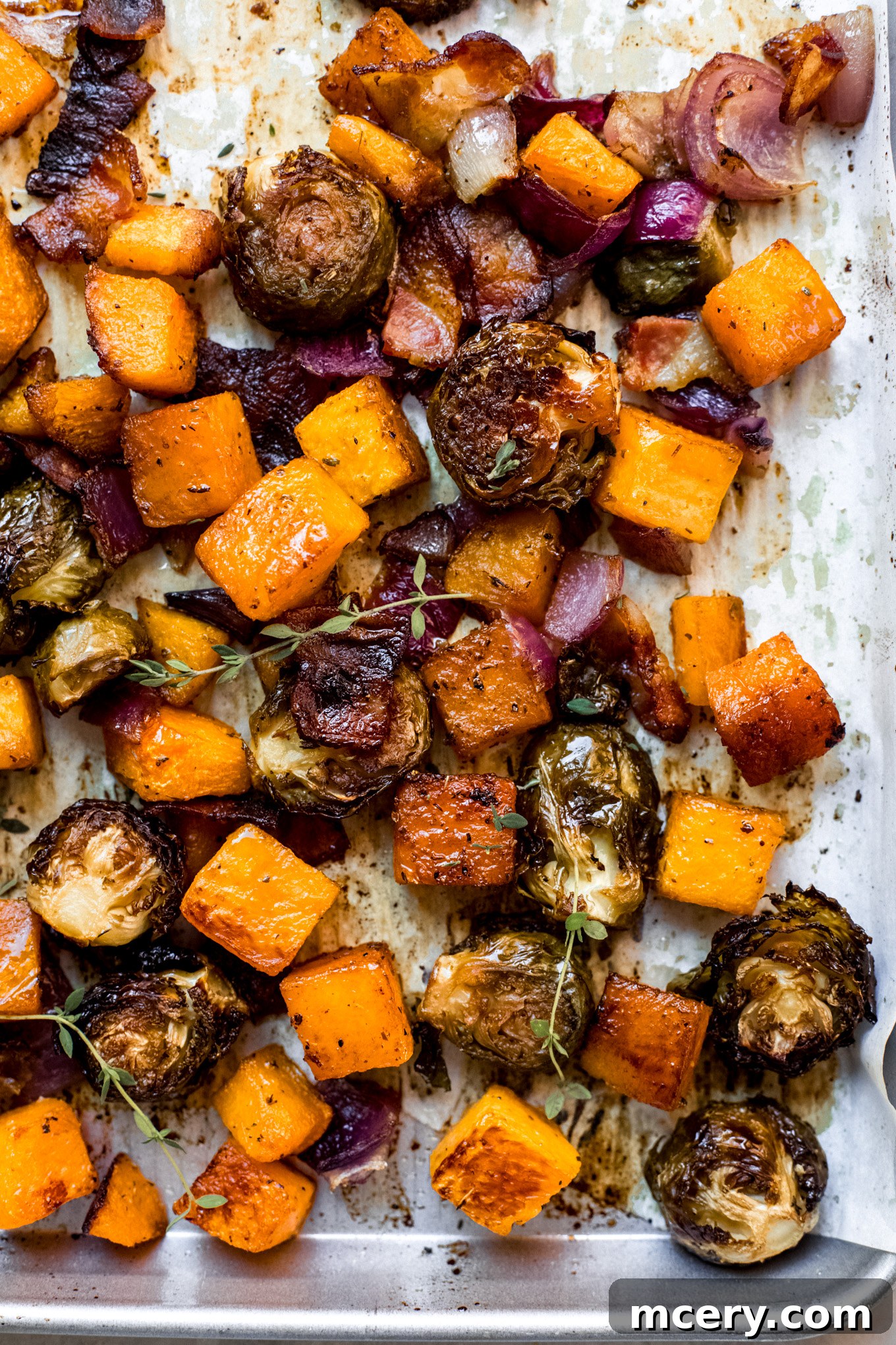Autumn Roasted Bounty 2 Roasted Brussels sprouts, butternut squash, and red onion on a sheet pan, ready to be served.