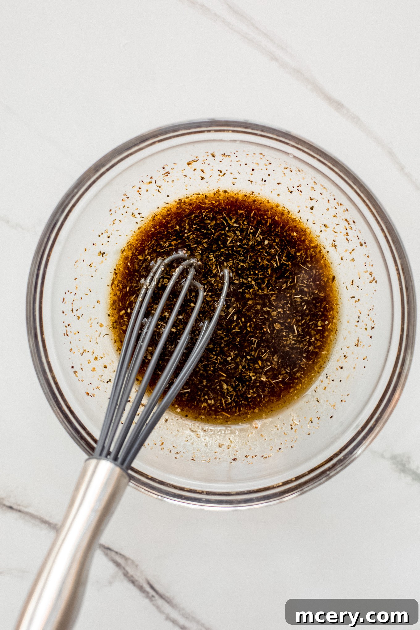 Autumn Roasted Bounty 5 A small bowl containing olive oil, balsamic vinegar, honey, and seasonings, with a whisk.