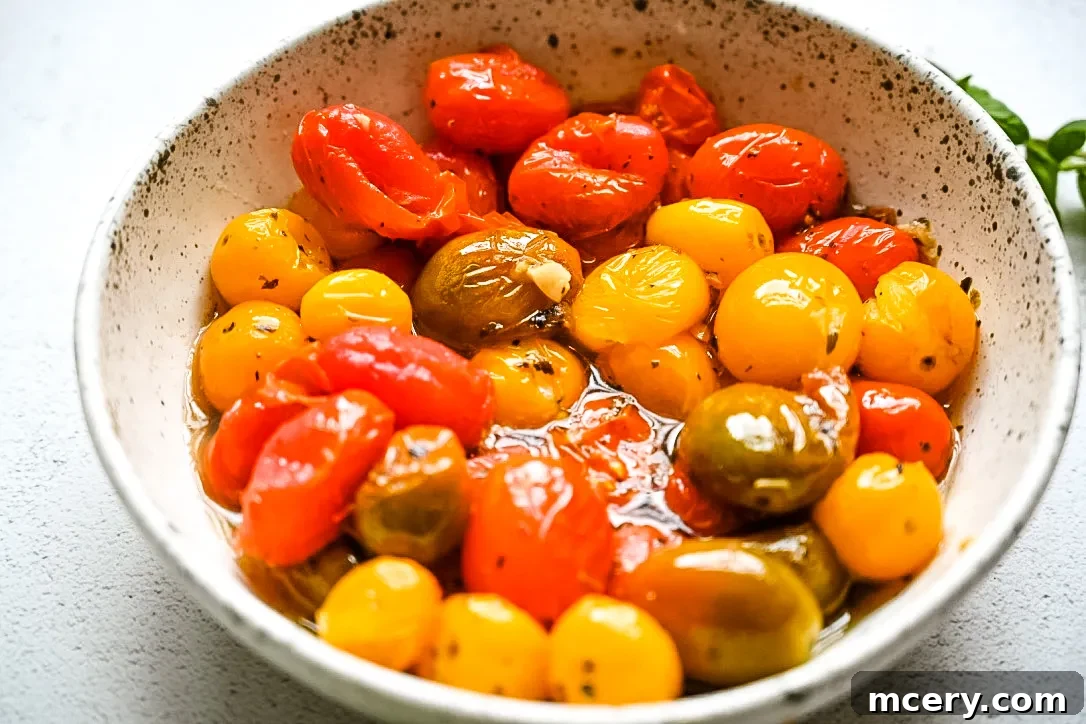 A dish of oven-roasted tomatoes and burrata, showing the creamy cheese melting into the warm tomatoes.