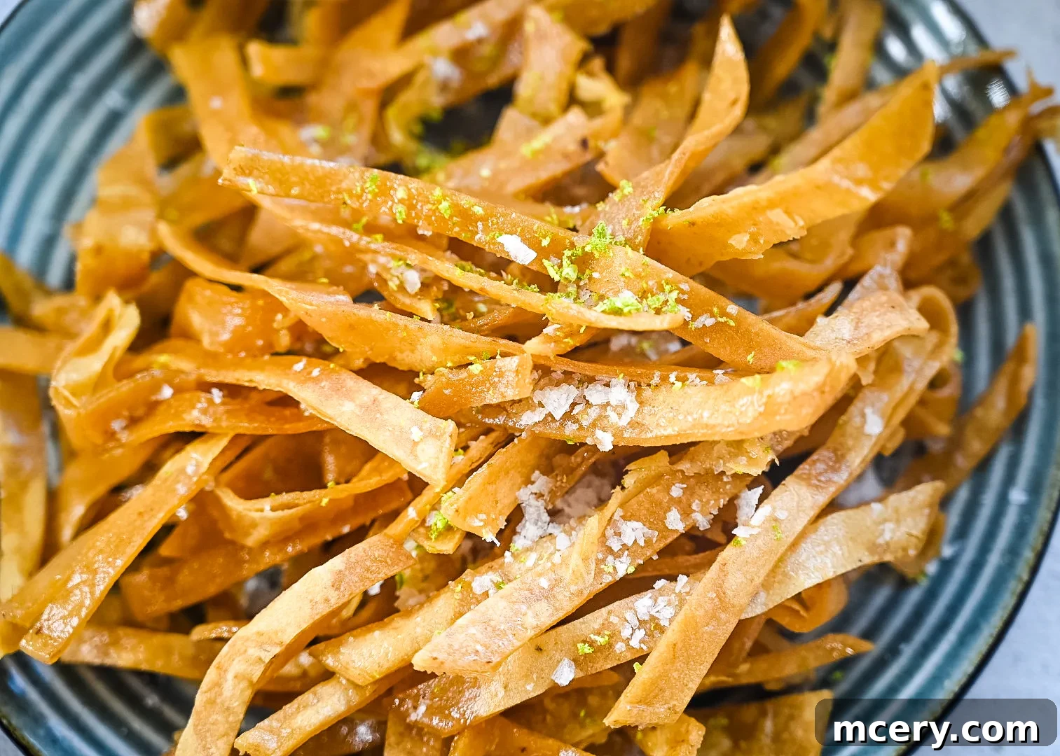 Speedy Southwestern Chicken Tortilla Soup 8 Close-up of crispy, golden-brown tortilla strips piled on a paper towel-lined plate.