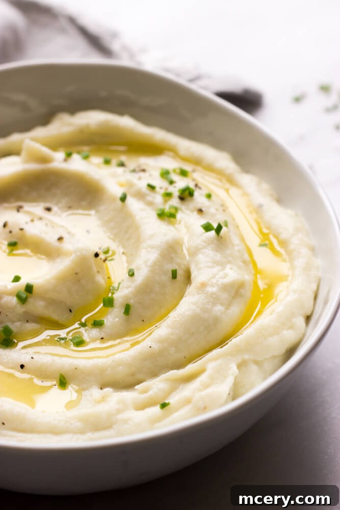 Close-up of fluffy mashed cauliflower with garlic and ricotta, garnished with fresh herbs