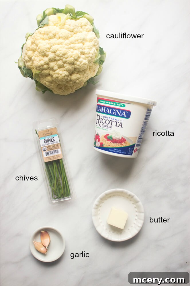 Ingredients for cauliflower mash laid out: cauliflower, ricotta, garlic, butter, chives