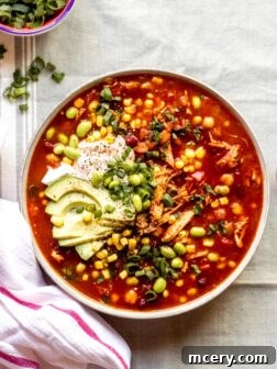 overhead photo of leftover turkey chili recipe, garnished with toppings, in a serving bowl.