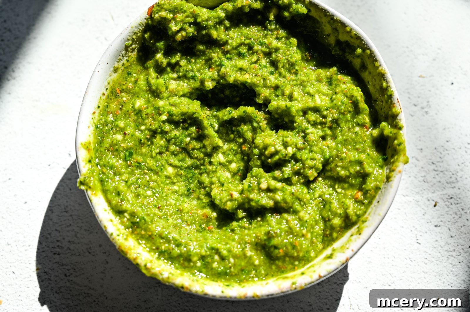 Velvet Burrata with Roasted Tomatoes and Fiery Pesto 6 Close-up of spicy pesto being prepared in a small food processor