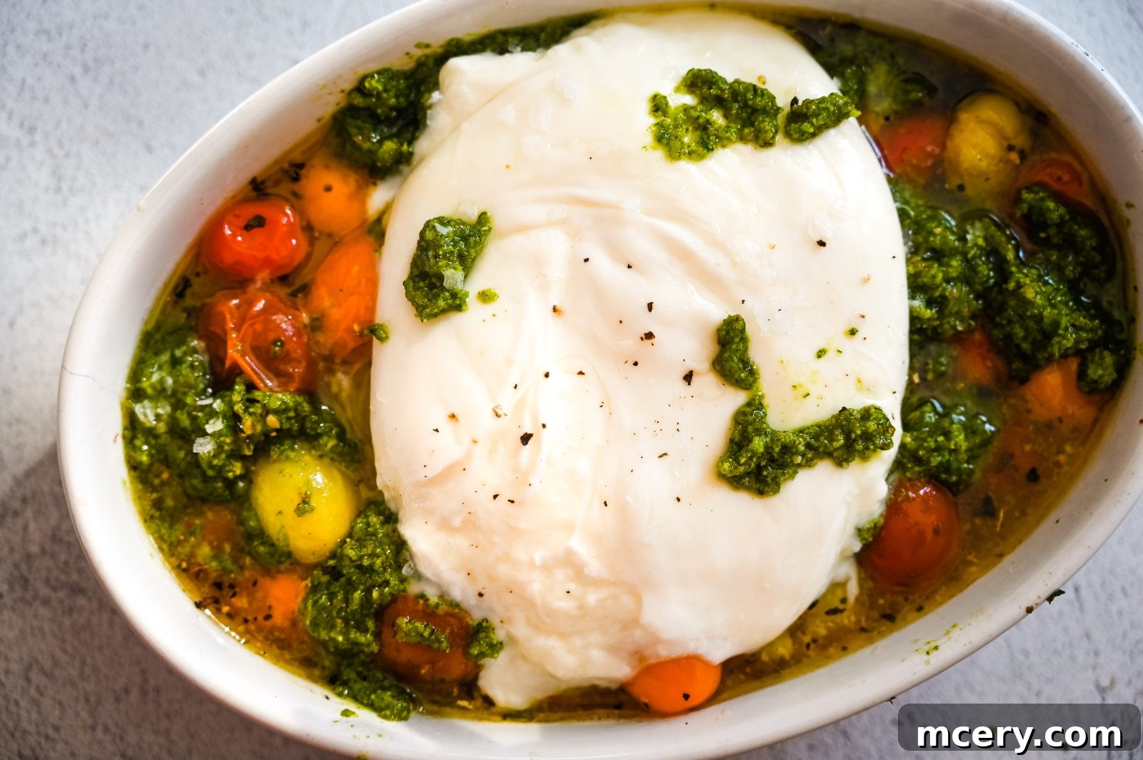 Velvet Burrata with Roasted Tomatoes and Fiery Pesto 7 Burrata with Roasted Tomatoes & Spicy Pesto arranged beautifully in a dish with toast