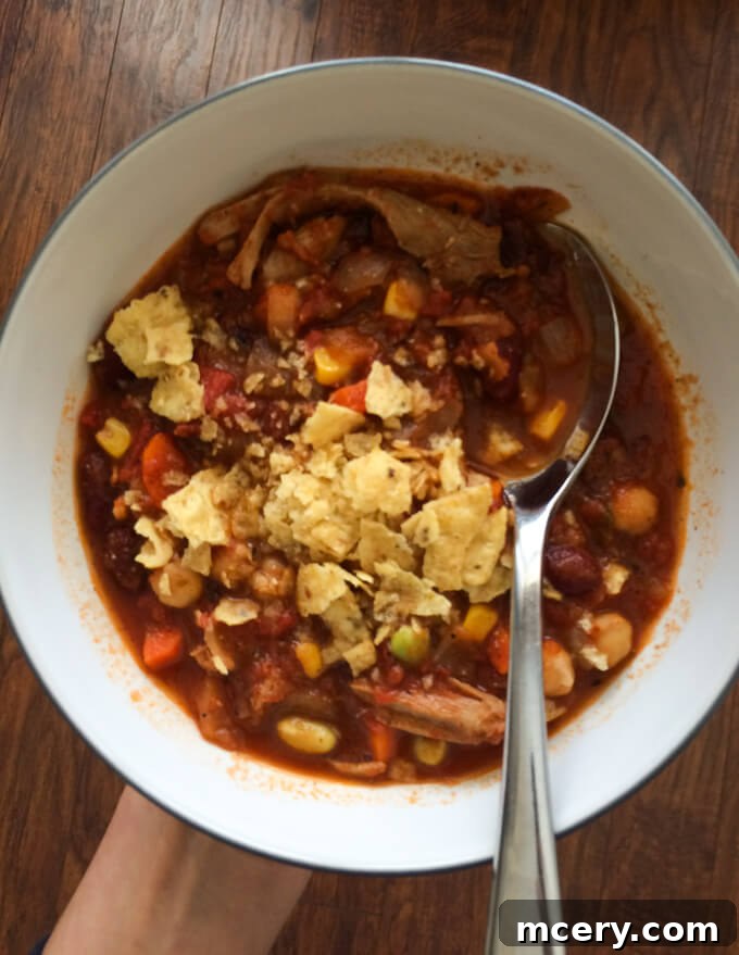 A bowl of hearty leftover turkey chili topped with crunchy tortilla chips for a nutritious dinner.