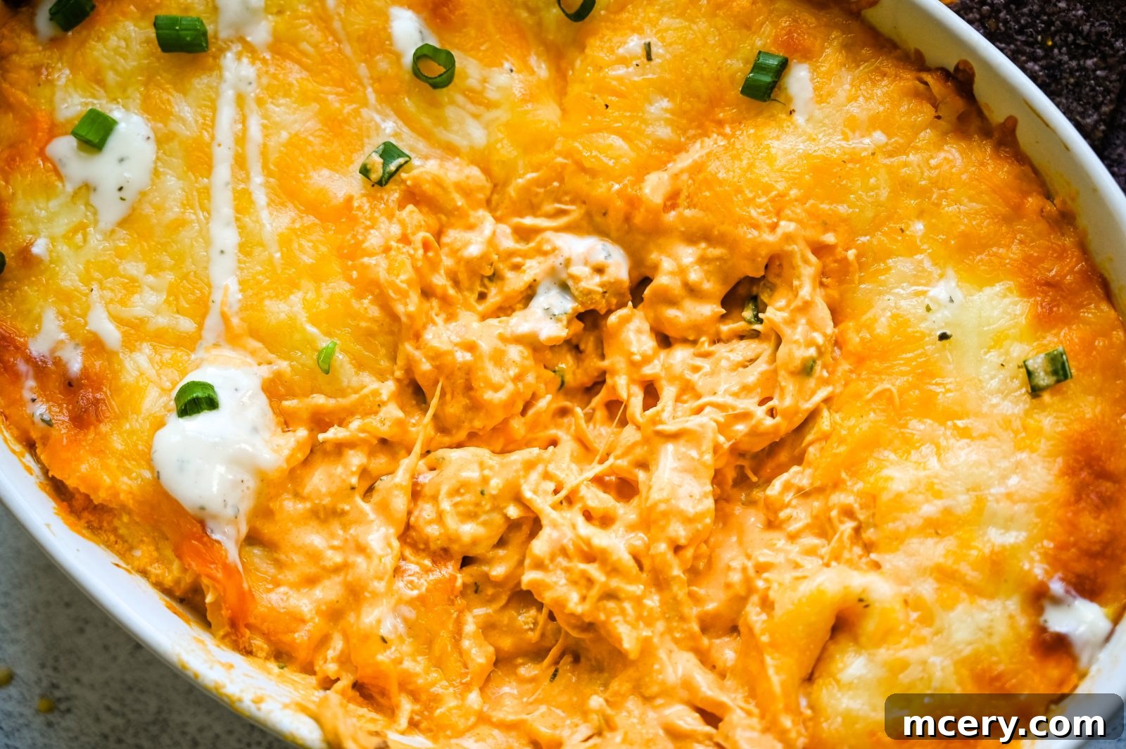 Ultimate Game Day Chicken Dip 2 Creamy, cheesy Buffalo Chicken Dip in a baking dish, garnished with green onions.