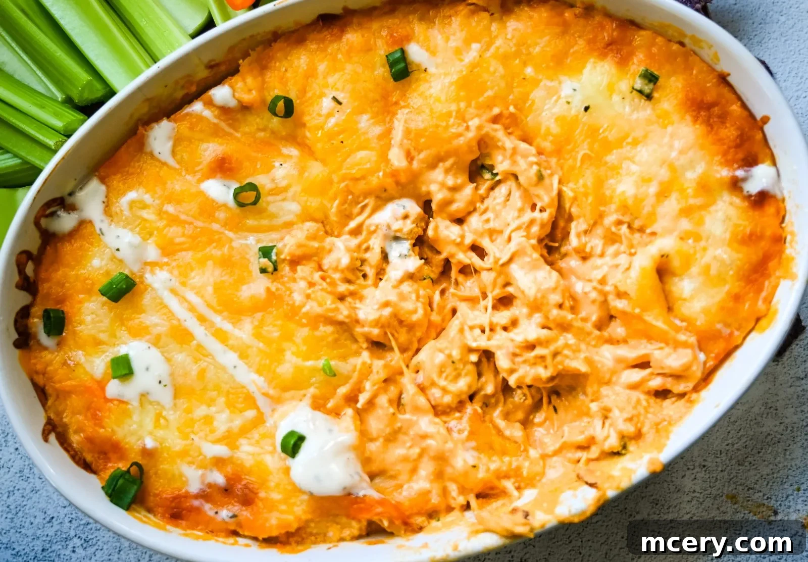 Ultimate Game Day Chicken Dip 11 Final presentation of the Buffalo Chicken Dip with fresh garnishes.