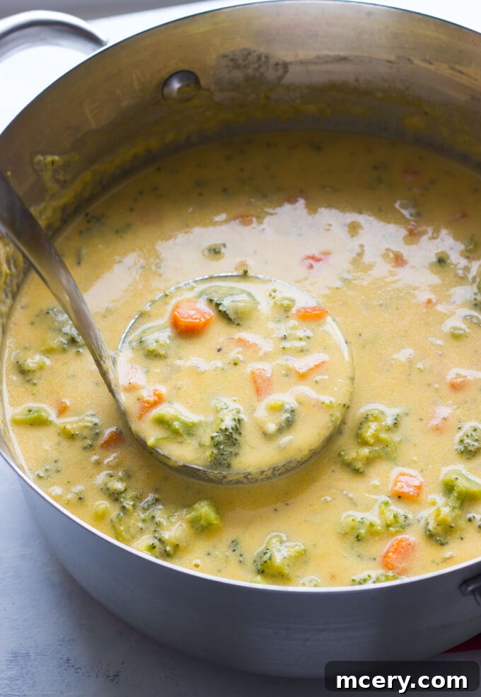 Golden Broccoli Cheddar Bliss 5 A close-up view of creamy, healthy broccoli cheddar soup simmering in a Dutch oven, ready to be served.