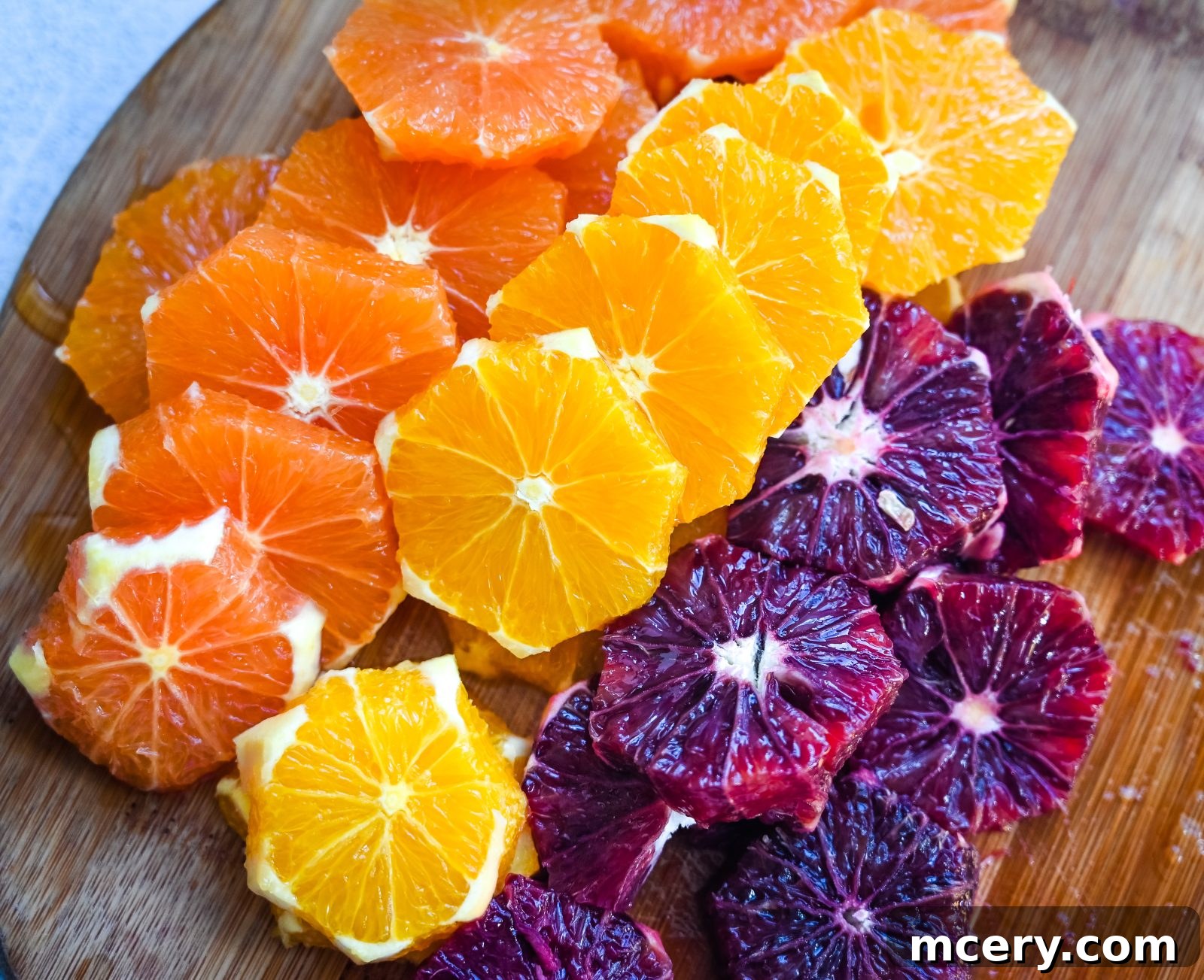 Effortless Citrus Delight 3 A close-up view of freshly peeled and sliced citrus fruits, including navel oranges, blood oranges, and Cara Cara oranges, arranged on a cutting board, ready for the salad preparation. This image emphasizes the freshness and vibrant colors of the citrus.