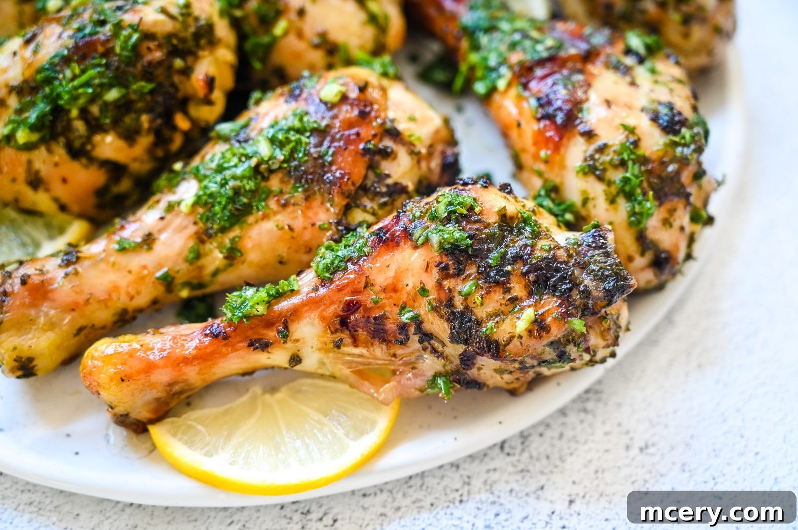 Golden Baked Chicken Drumsticks 3 Close-up of a perfectly cooked baked chicken leg, glistening with marinade and herbs.