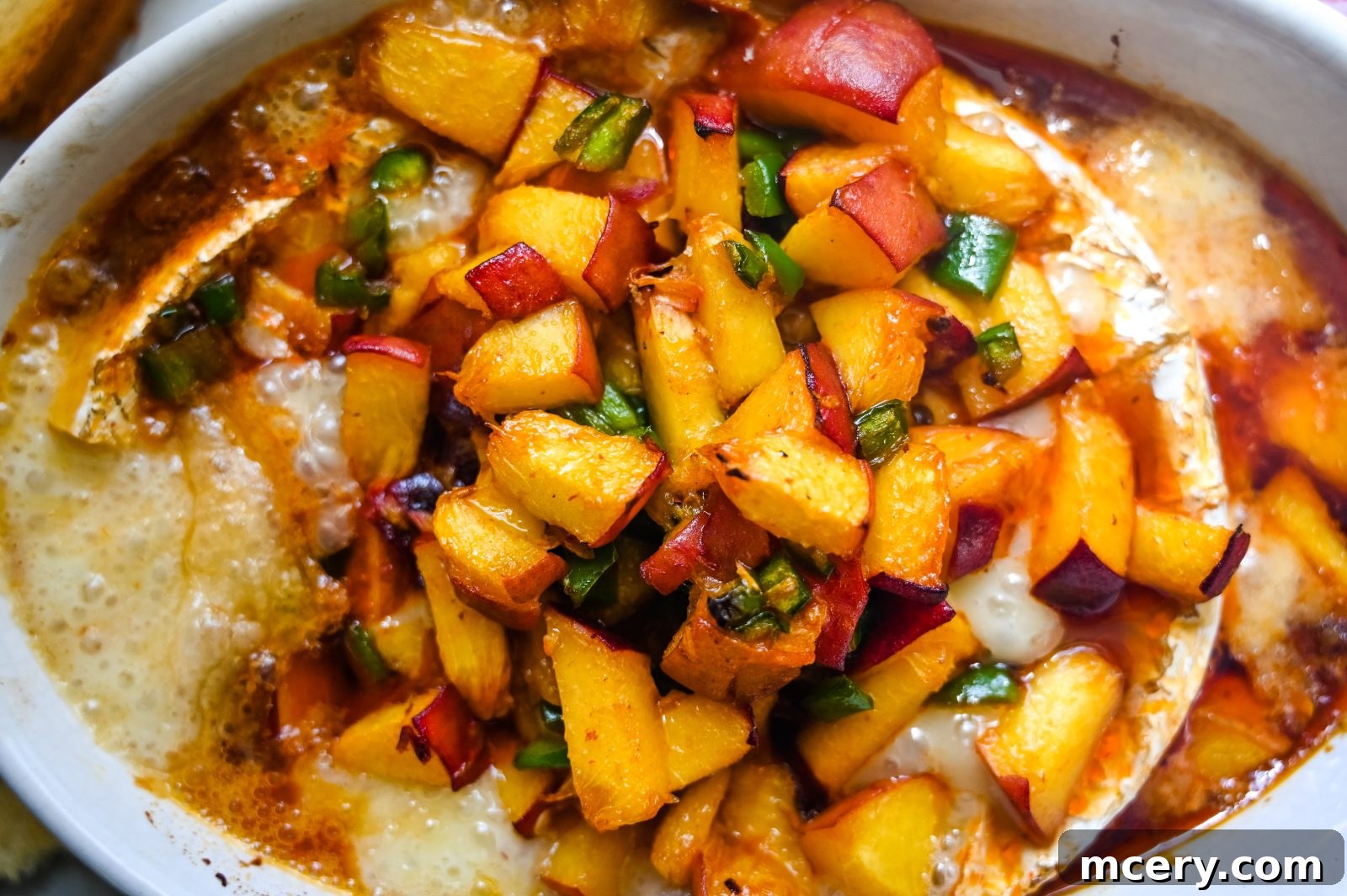 Baked Brie with Sweet Peach and Smoky Chipotle 5 Fresh ingredients for Honey Peach & Chipotle Baked Brie, including a wheel of brie, a ripe peach, a jalapeño, honey, and a can of chipotles in adobo sauce.