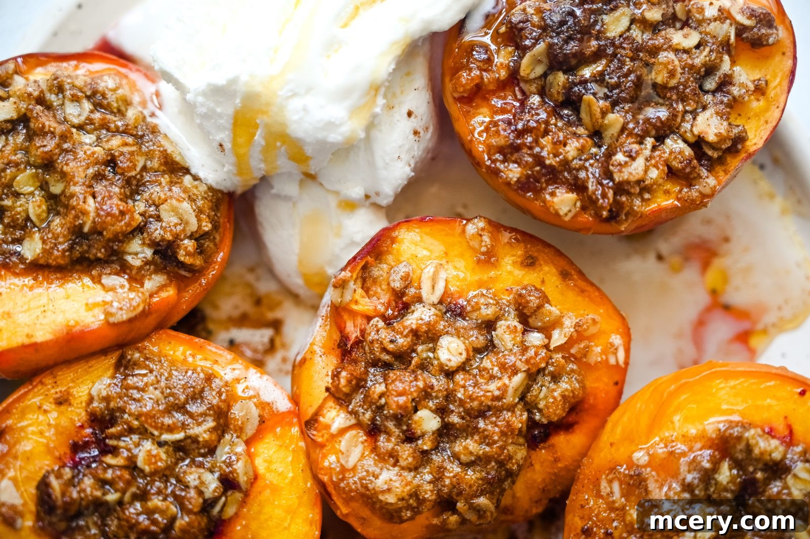 Sun-Kissed Peach Crumble 2 Two halves of baked peaches with a golden brown oat crisp topping, served in a white bowl with a spoon, ready to be enjoyed.