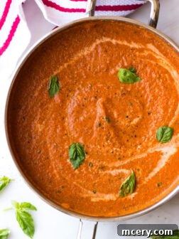 Close up of homemade creamy pink vodka sauce simmering in a sauté pan, featuring its rich texture and inviting color before serving.