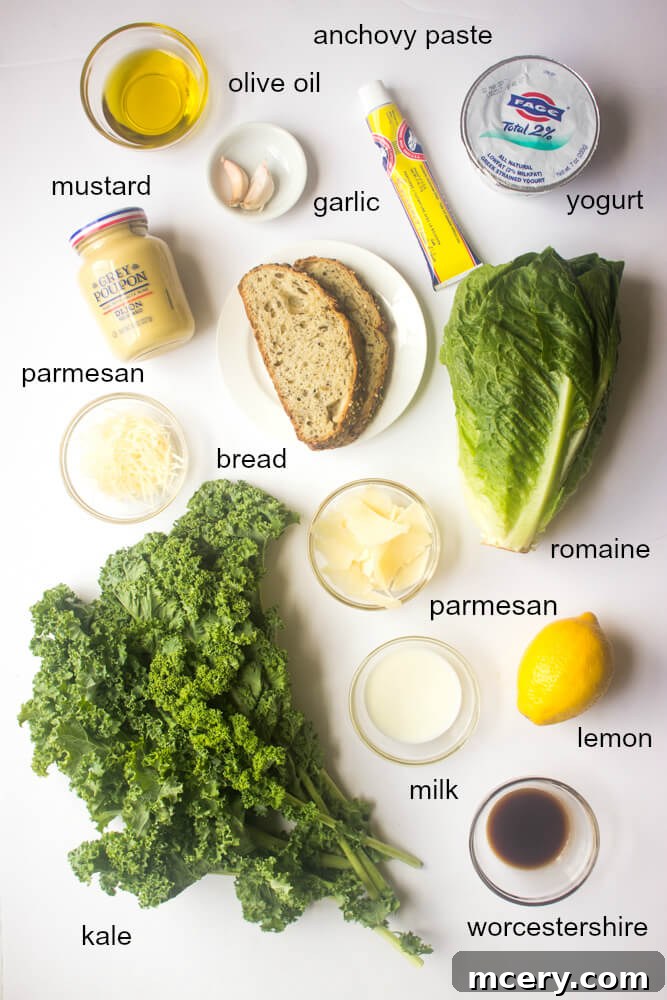 A close-up of the ingredients laid out for Kale Caesar Salad, including fresh kale, romaine, croutons, and dressing components.