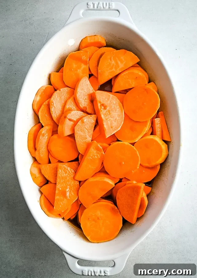 Decadent Candied Sweet Potatoes 5 The full spread of Candied Sweet Potatoes in a baking dish, showcasing the vibrant orange color, toasted marshmallows, and candied pecans, ideal for a holiday feast.