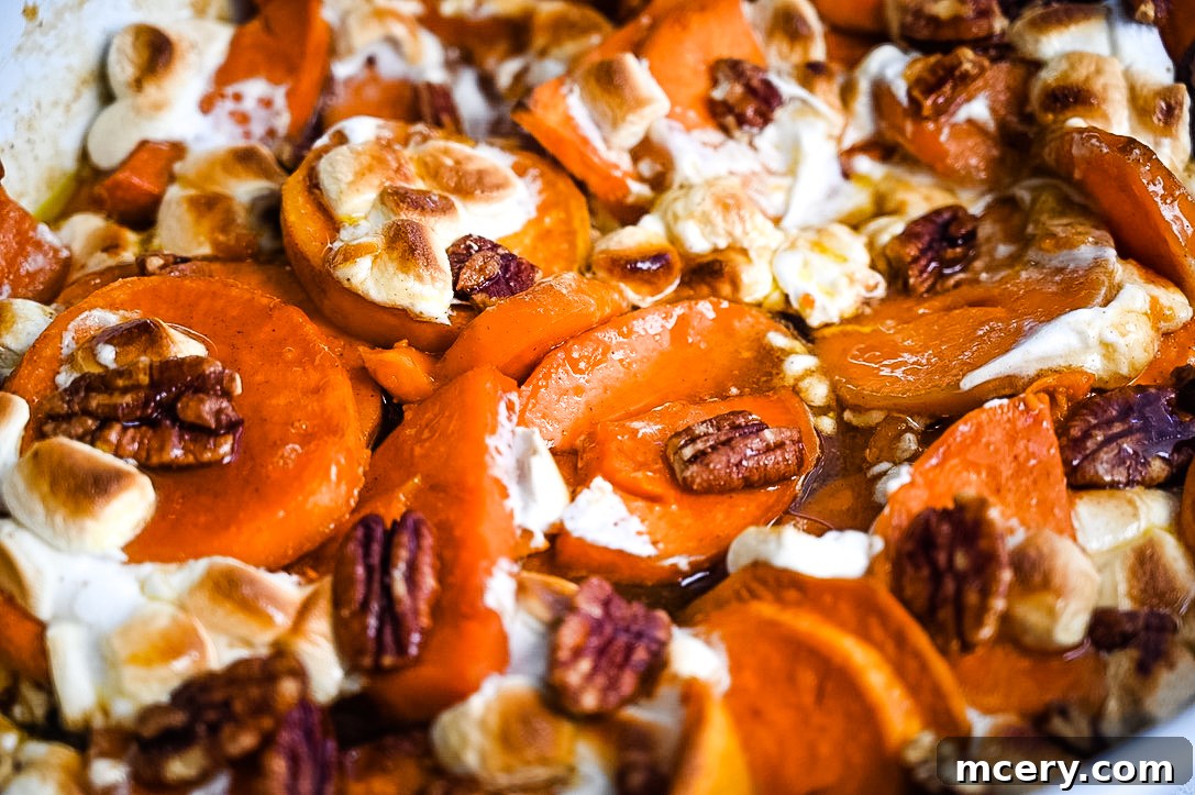 Decadent Candied Sweet Potatoes 6 A festive holiday table setting featuring the star dish, Candied Sweet Potatoes, beautifully garnished and surrounded by other delectable holiday foods, ready for a family feast.