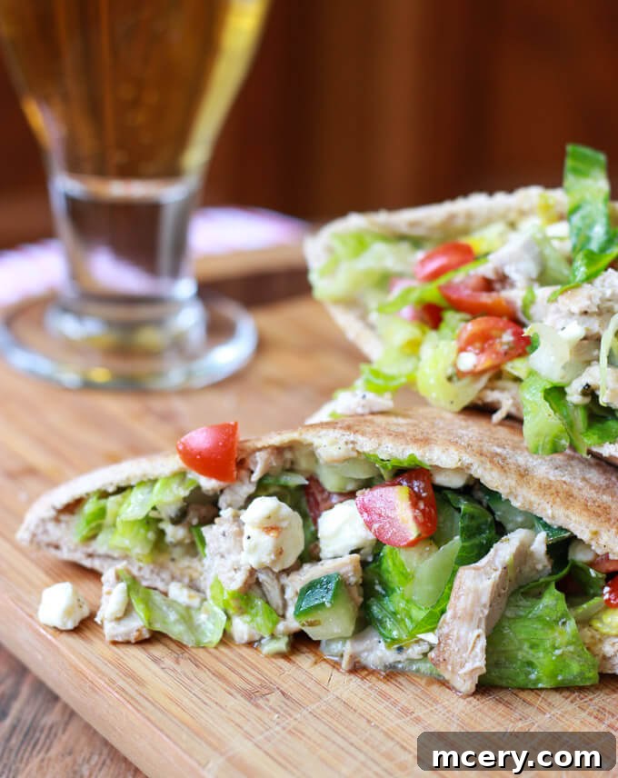Greek chicken salad stuffed into a pita pocket, highlighting the fresh ingredients and the appealing presentation.