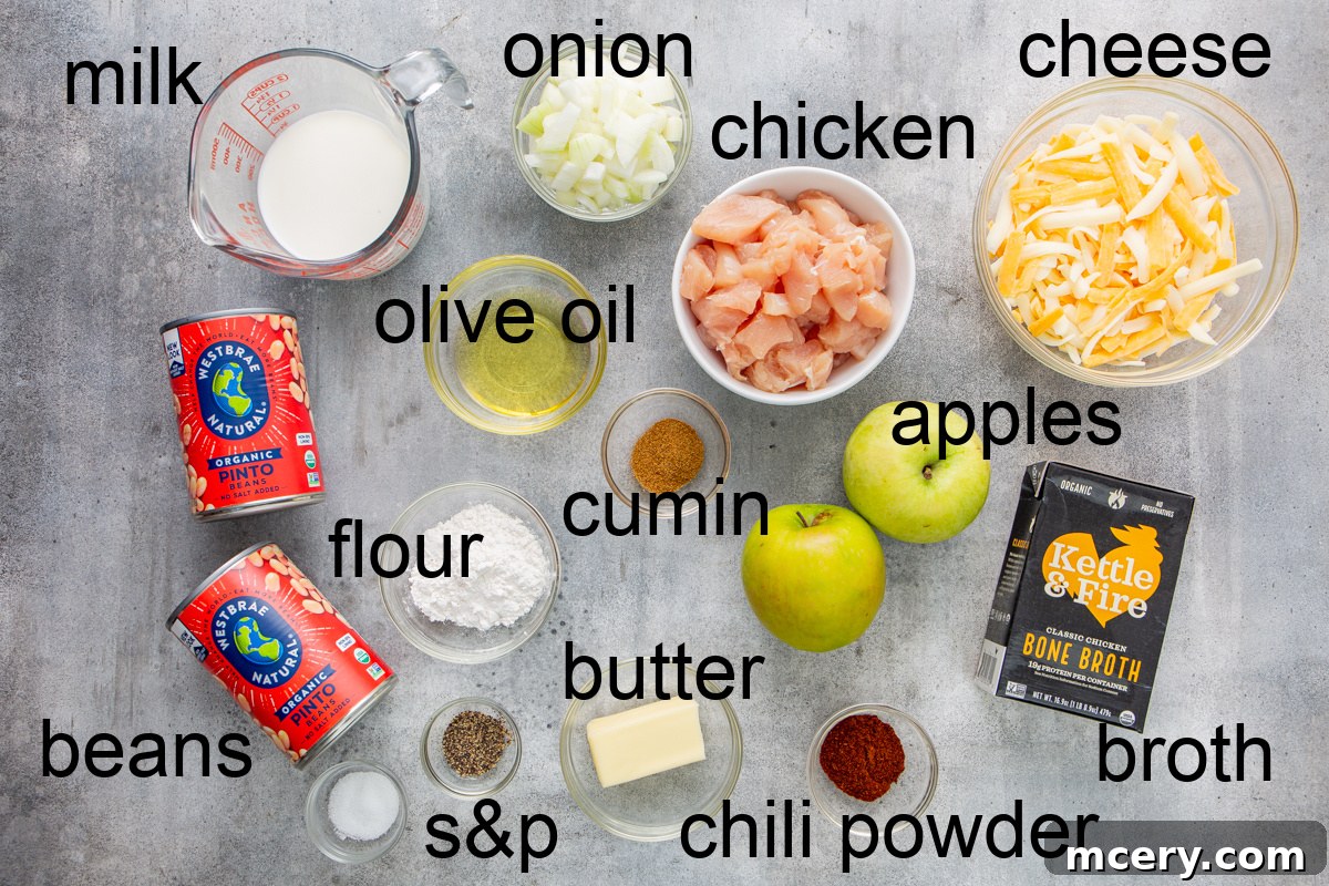 Sweet and Savory Chicken Apple Chili 3 A vibrant flat lay image showcasing all the fresh ingredients needed for creamy chicken chili with apples, including chicken, apples, beans, spices, and dairy.
