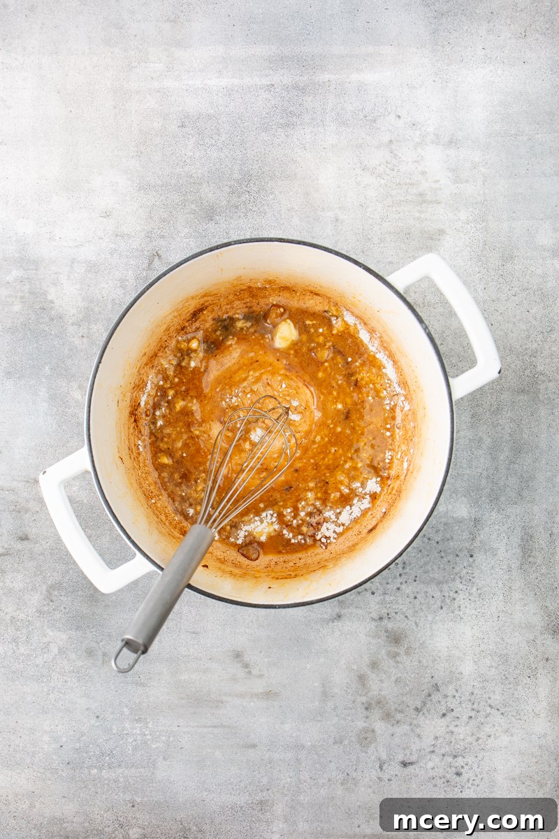Sweet and Savory Chicken Apple Chili 6 A smooth roux forming in a Dutch oven, with melted butter and flour being whisked together, creating the base for a creamy sauce.