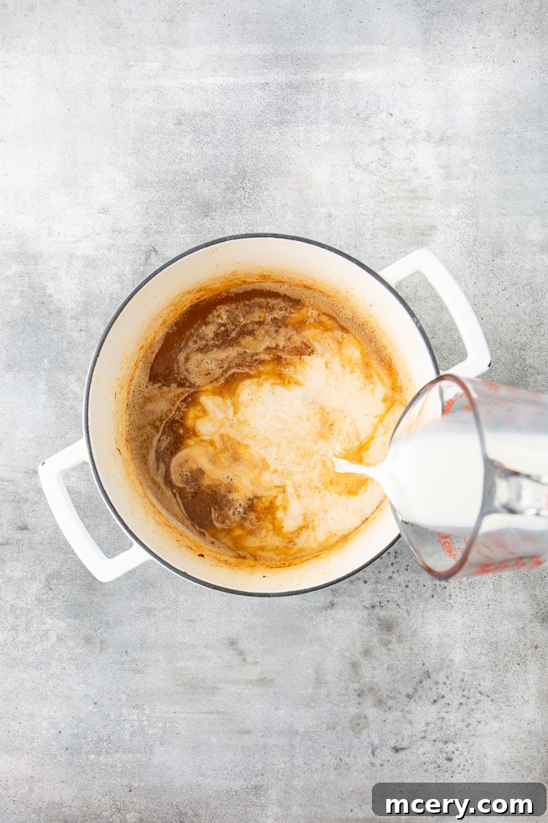 Sweet and Savory Chicken Apple Chili 7 Rich chicken stock and creamy milk being slowly poured into a Dutch oven, gradually transforming the roux into a luscious, thickening sauce.