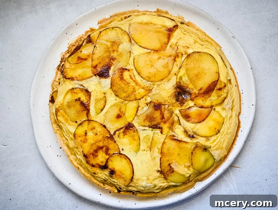 Effortless Egg Potato Frittata 7 Egg mixture poured over golden potatoes in a skillet before baking.