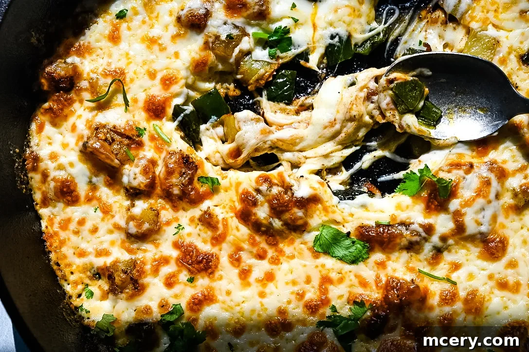 Irresistible Queso Fundido 4 A cast iron skillet filled with bubbling QUESO FUNDIDO, garnished with fresh cilantro.