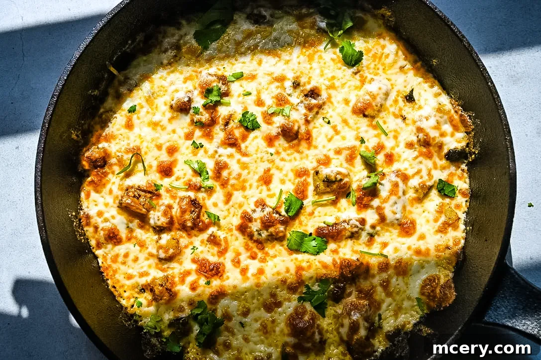 Irresistible Queso Fundido 8 Close-up of the bubbly, golden-brown edges of QUESO FUNDIDO in a cast iron skillet.