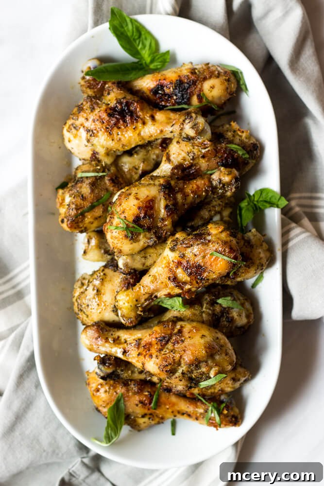 Golden Herb-Roasted Chicken 5 Close-up of baked chicken drumsticks with fresh garlic and herbs garnish