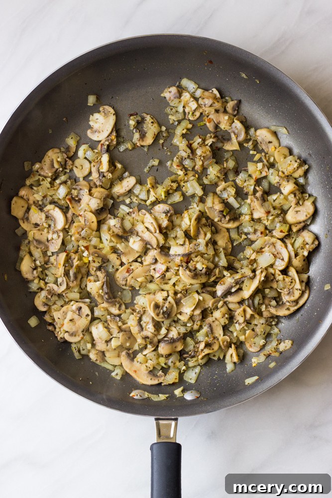 Creamy Chicken Lasagna with Spinach and Mushrooms 5 Sautéed mushrooms, onions, garlic, and spices cooking in a large skillet until softened.