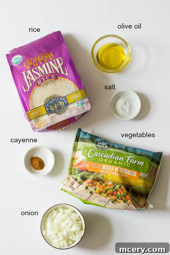 Flavorful Mexican White Rice 3 Assortment of fresh and frozen ingredients laid out on a wooden board, featuring jasmine rice, white onion, olive oil, frozen vegetables, kosher salt, and cayenne pepper, essential for making delicious Mexican white rice.