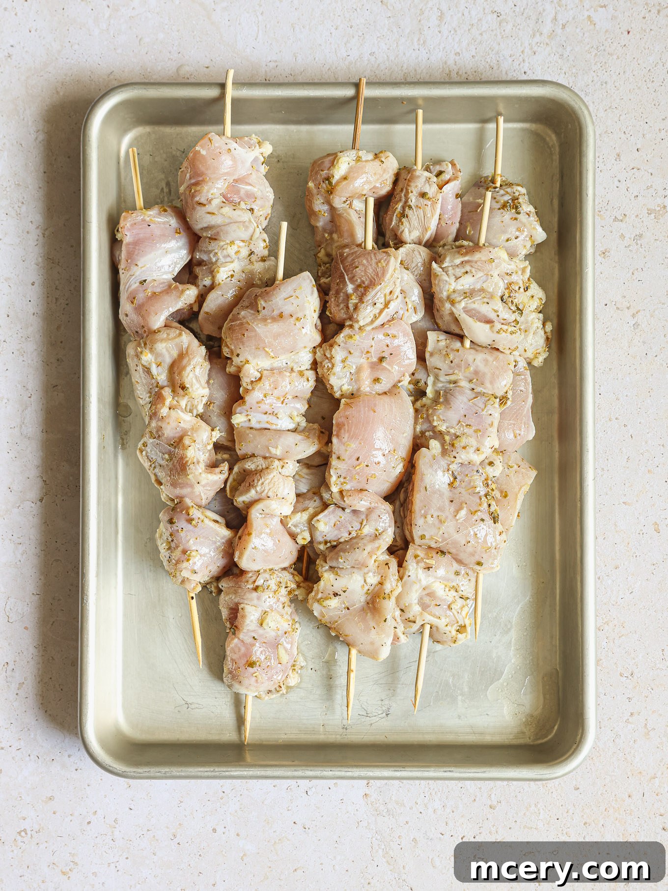Homemade Chicken Gyro Perfection 8 Raw marinated chicken threaded onto wooden skewers.