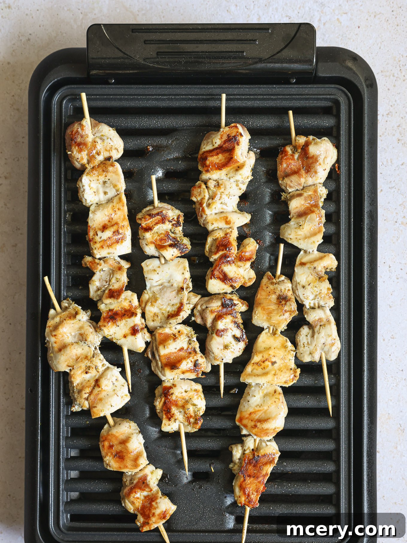 Homemade Chicken Gyro Perfection 9 Chicken skewers grilling on a hot outdoor grill.