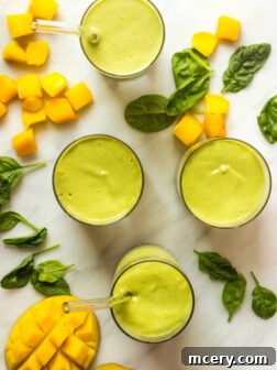 A green power smoothie with a straw, photographed to show its creamy texture, highlighting its appeal as a healthy drink.