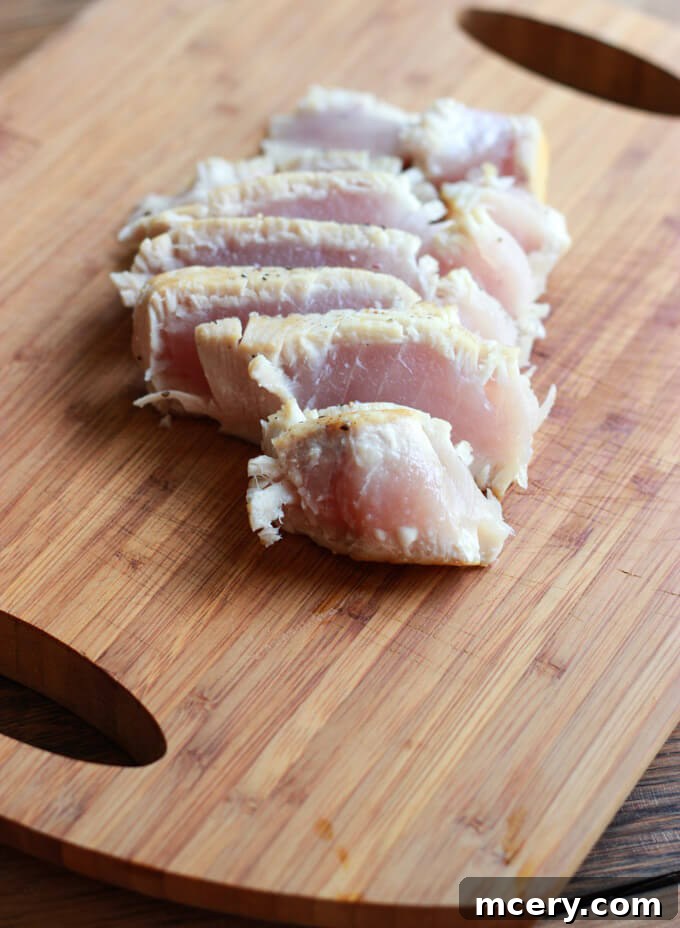 Perfectly cooked and thinly sliced tuna steaks, arranged on a wooden board, showcasing their beautiful pink center.