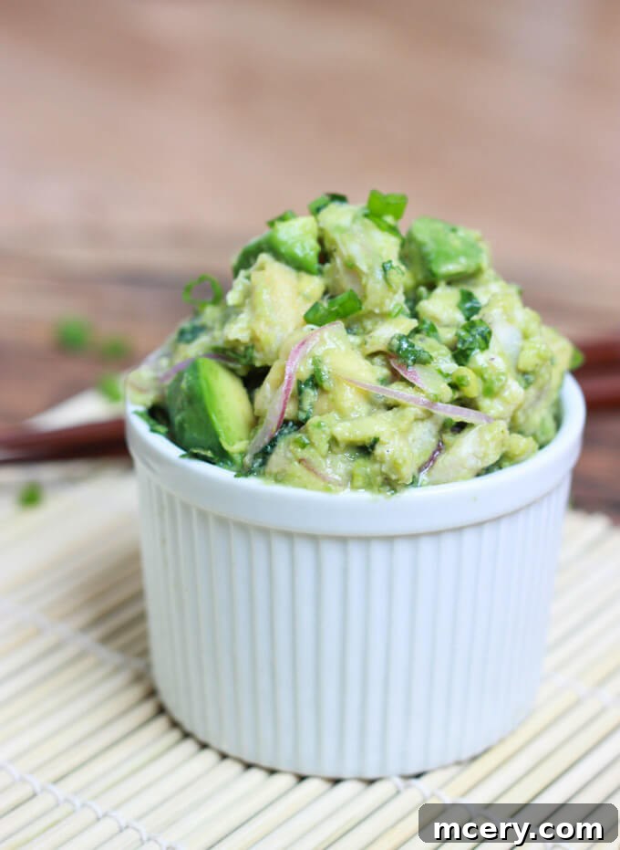A close-up side view of Ina Garten's fresh tuna salad with avocado, served in a white bowl, highlighting its vibrant colors and textures.
