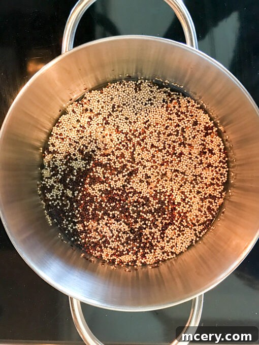 Mediterranean Chicken Quinoa Medley 4 quinoa simmering in water inside a small saucepan.