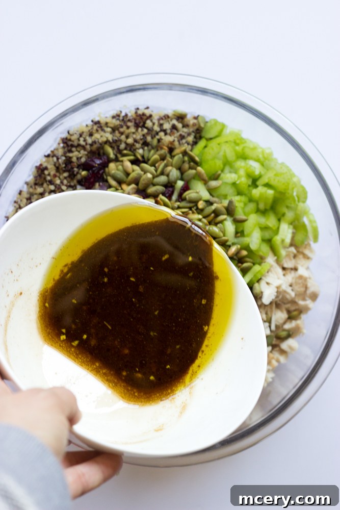 Mediterranean Chicken Quinoa Medley 8 balsamic dressing being poured over the mixed quinoa salad in a large bowl.